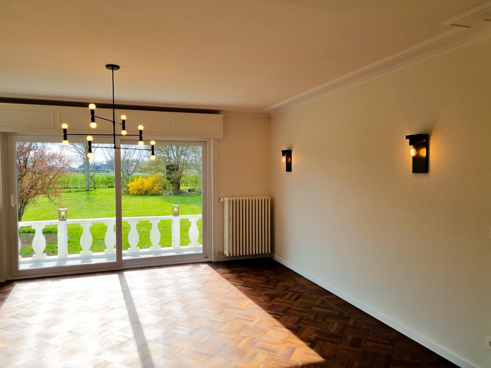 Woonkamer met sfeervolle wandverlichting en luster